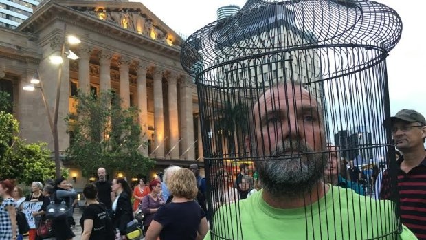 Paul Mansfield wears a cage symbolising the imprisonment of asylum seekers.