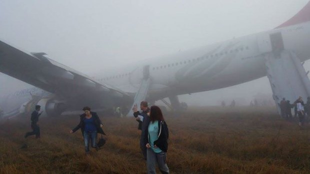Passengers walk away from a Turkish Airlines plane after it skidded off the runway.