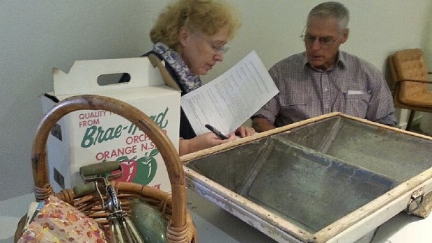 Orange City Council's museum adviser Kylie Winkworth with Les Wright and his kero tin washing up dish.
