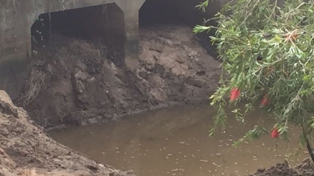 Police are searching the 100 cubic metres of soil inside this drain at Carole Park, which has been removed in the past week.