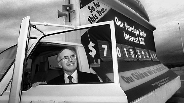 Former prime minister John Howard with the 'debt truck' on the forecourt of Parliament House.