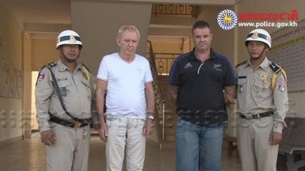 Victorian man Guido James Eglitis (left) and another foreign suspect under arrest in the Cambodian town of Siem Reap last year.