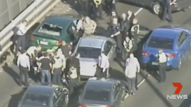 Police surround the driver on the West Gate Bridge.