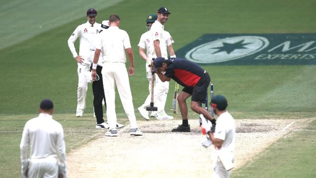 Running repairs: A groundsman takes a sledgehammer to the MCG pitch during the Boxing Day Test.