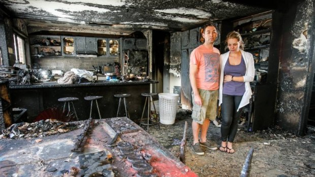 John and Lani Balzan exam the burnt mess of their Figtree home. 