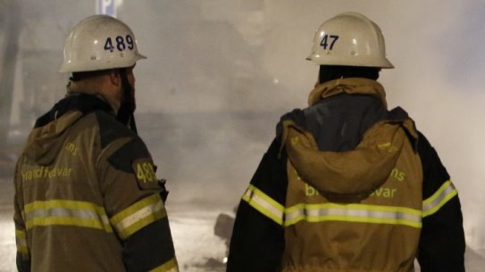 Firefighters keep watch over the riot. in the Stockholm suburb of Rinkeby.