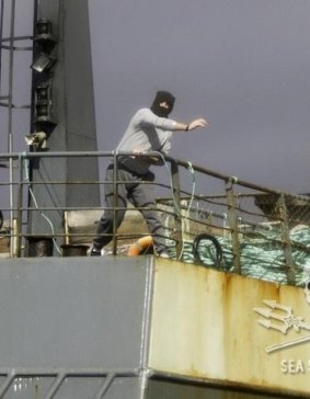 A masked crewman from the toothfish poacher Thunder throws something at Sea Shepherd activists.