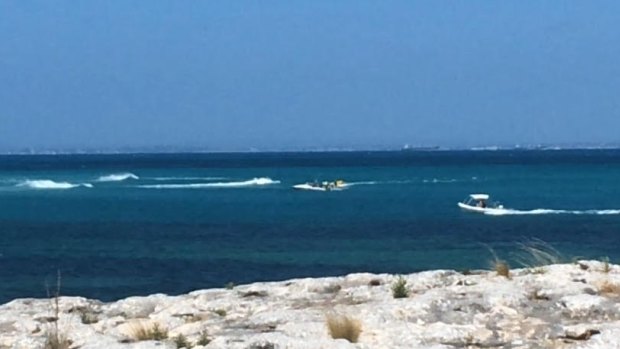 Two boats rush out to pick up surfers after a 2.5 metre shark was spotted 200 metres from shore. 