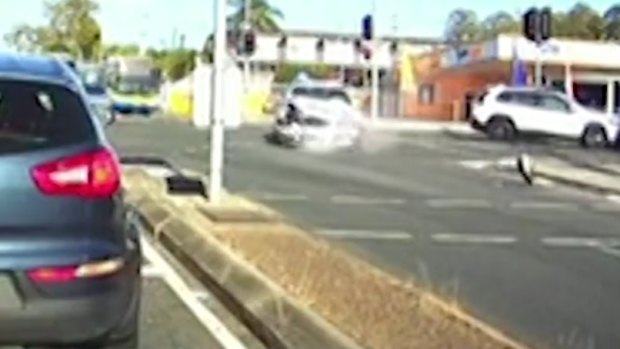 Dashcam captures the moment a driver crashes into a police car at an intersection in Stafford, Queensland on Friday morning.