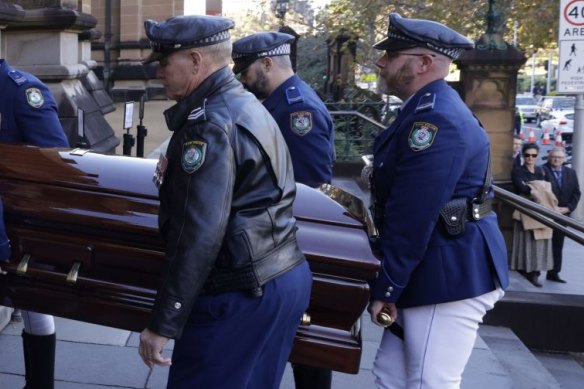 Russell, a Manly fan of 61 years, salutes the the coffin carrying Robert Fulton at St Mary’s Cathedral.