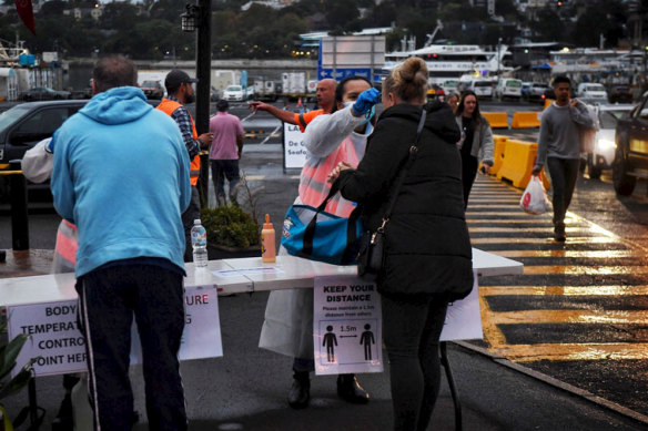 Shoppers at the fish market have their temperatures taken at the entrance on Good Friday. 