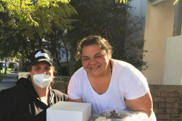 Jan Earl (left), a member of the South Sydney Rabbitohs’ welfare team, provides a hamper for Jacqueline Moale, the mother of NRL player Davvy Moale.