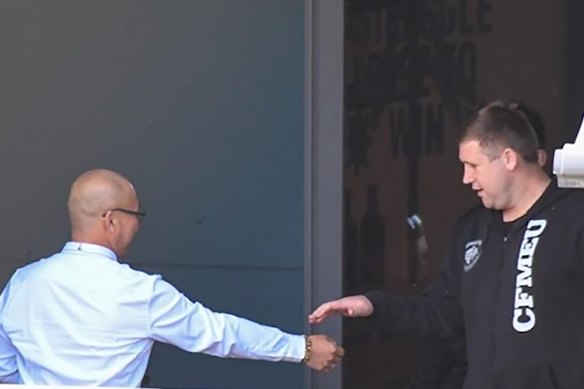 Former CFMEU NSW assistant secretary Michael Greenfield (right) and secretary Darren Greenfield (left, obscured) at union headquarters with an employer they received $5000 bribes from.