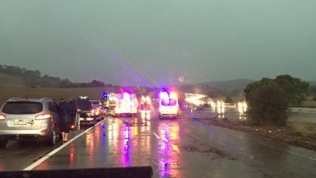 Emergency crews respond to cars swept off the Federal Highway due to flooding.