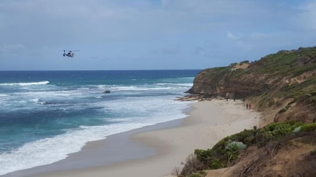 Police helicopter searching rough surf for missing fisherman Yik Sua Hong.