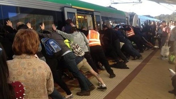 People get off the train to help push the train and free the man.