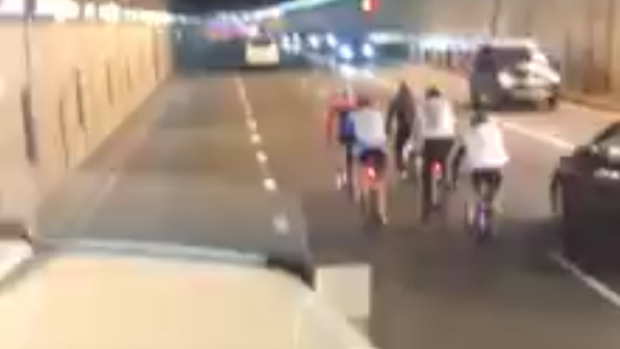 The group of cyclists travel through the tunnel near Sydney Airport.