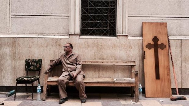 A man sits on a bench outside a church after a bomb attack in the Nile Delta town of Tanta on Palm Sunday. 