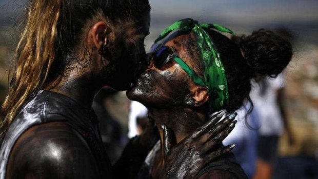 A couple painted with black grease kiss each other as they take part at the traditional festivities of the Cascamorras festival in Baza, Spain. 