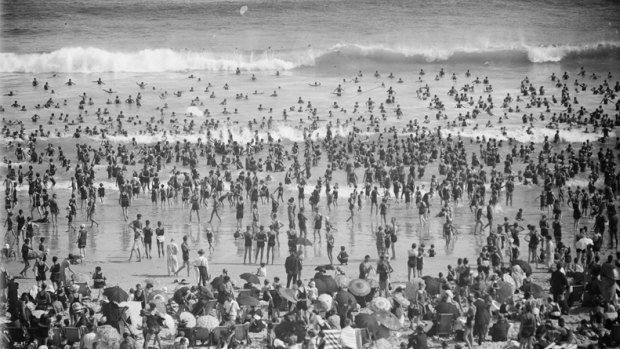 Crowds sunbathing and swimming at Bondi Beach, Sydney, ca. 1930's.