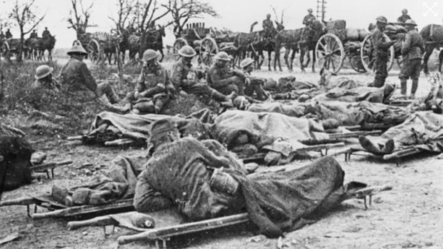 Australian and German wounded lying on stretchers waiting for ambulance assistance, 8 August 1918.