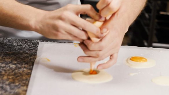 Piping the orange 'yolk' onto the white chocolate 'white'.