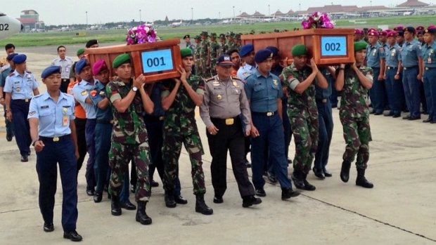 The first two bodies recovered from the doomed flight, carried in coffins labelled as 001 and 002. 