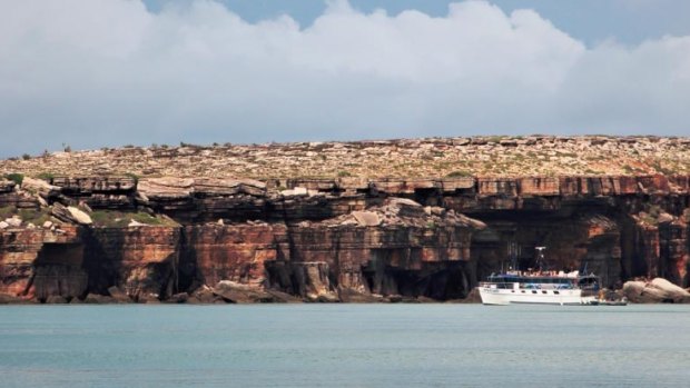 The MY Wildcard is dwarfed by the high cliffs of the Wessel Islands' rugged east coast.