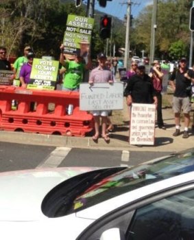 Former Young LNP leader Ben Riley stands with a satirical sign alongside demonstrators.