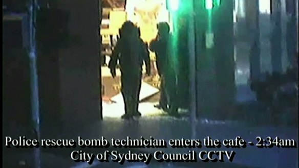 Bomb squad technicians enter the cafe after the siege.