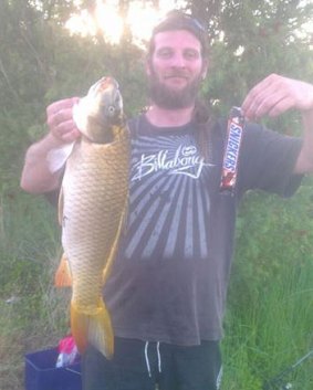 Clay Anderson with a slightly smaller carp. Snickers Bar for size comparison.
