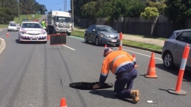 Council maintenance workers at the scene where a hole opened up on a road at Maroochydore.