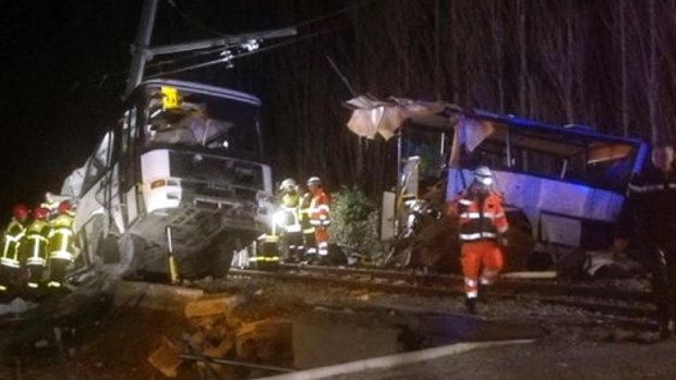 Rescue workers help after a school bus and a regional train collided in the village of Millas, southern France.