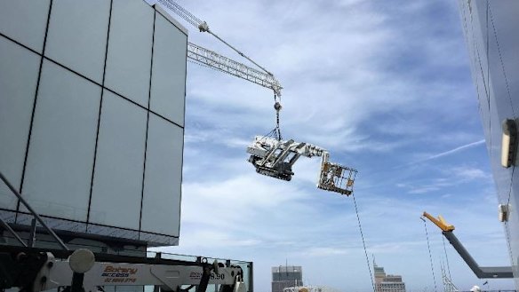 The crane dangles on top of Tower One at Barangaroo in Sydney's CBD.