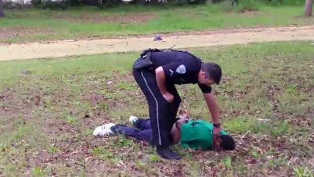 North Charleston police officer Michael Slager stands over 50-year-old Walter Scott after allegedly shooting him in the back as he ran away, in this still image from video.