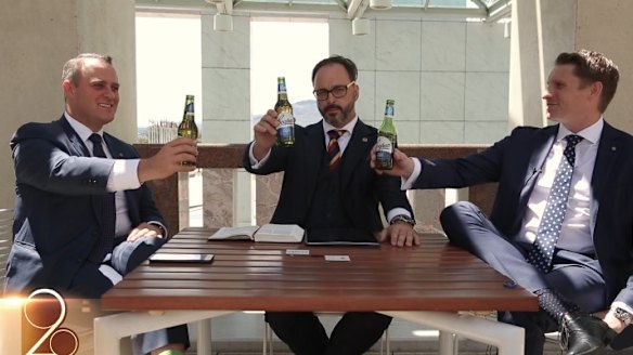 Liberal MPs Tim Wilson, left, and Andrew Hastie, right, hold up Coopers beer bottles in the video.
