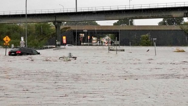 Queensland weather. A car floats away on what was previously roadway near Toombul Shopping Centre.