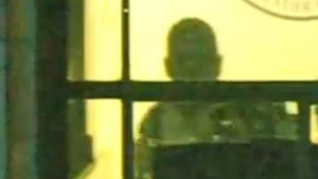 Gunman Man Haron Monis seen through a window of the Lindt cafe.