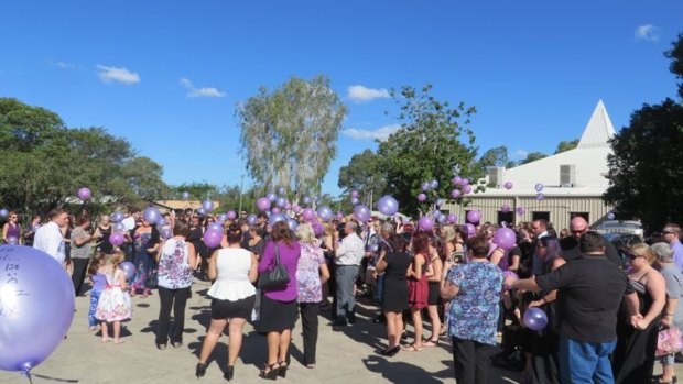 Mourners release purple balloons in memory of Talieha.
