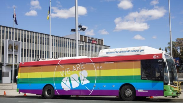 A bus painted in rainbow colours in support of marriage equality parks in front of the ACT Legislative Assembly.