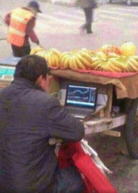 An image that went viral of a streetside banana vendor watching the stocks.