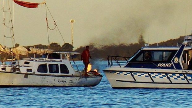A man refuses to leave his yacht, which he has set alight on Lake Macquarie, police say.