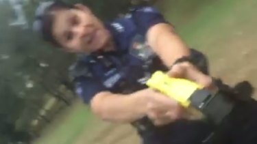 A Queensland police officer with a Taser appears in a video posted to Facebook.