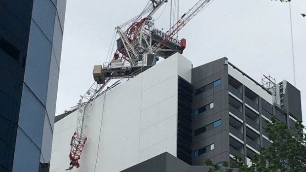 Workers dangle from a collapsed crane at a North Sydney building site.