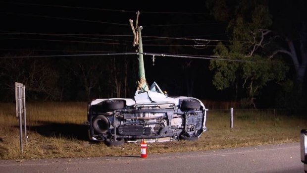 The Ford Ranger four-wheel-drive on its side resting against the smashed power pole.