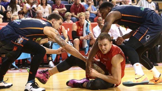 Scramble: Hawks forward Tim Coeneraad tries to keep the ball away from the Cairns defence.