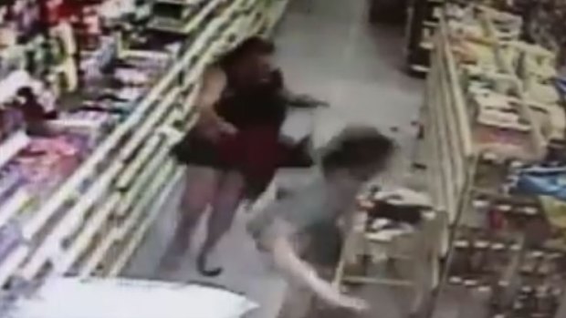 The mother chases the would-be kidnapper through the shop as he drags her daughter. 
