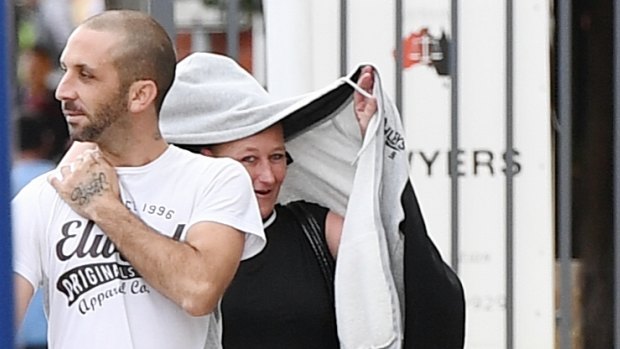 Nicole Boyle (right) tries to hide her identity as she arrives with her partner at Burwood Local Court.