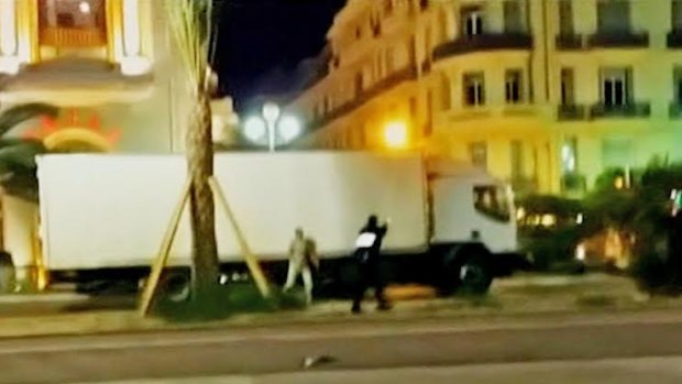 A police officer stands beside the truck which hit hundreds of people in Nice.