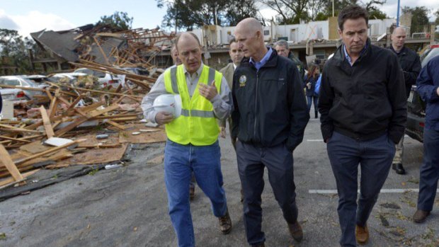 Florida Governor Rick Scott, centre, tours an apartment complex that was destroyed by a tornado in Pensacola, Florida on Wednesday.